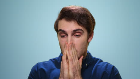 Sick-man-sneezing-in-studio.-Close-up-ill-guy-sneezing-on-blue-background