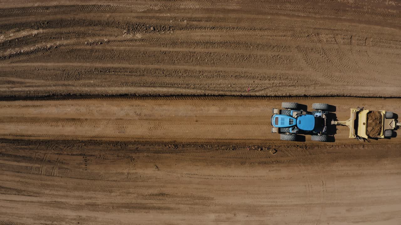 vista aérea de arriba hacia abajo de un tractor que mueve grandes cantidades de suelo