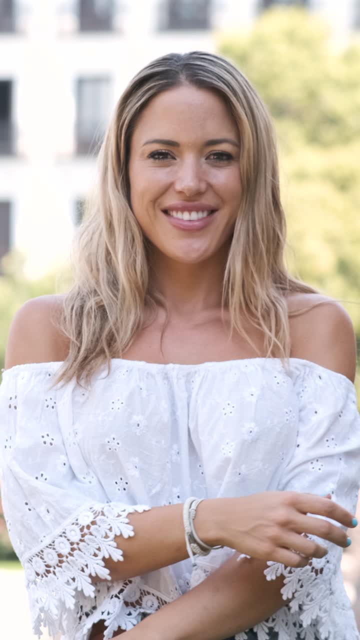 Woman in white off shoulder crop top standing at city park during sunny day