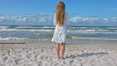 the woman is standing alone on the sunny beach