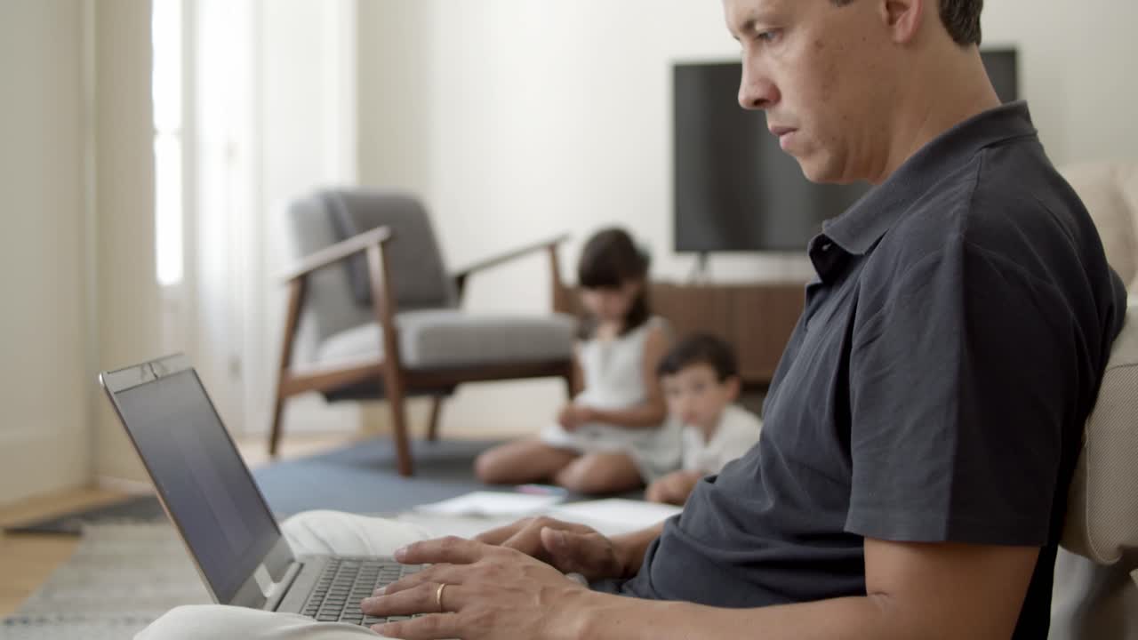 hombre enfocado con computadora portátil trabajando en casa