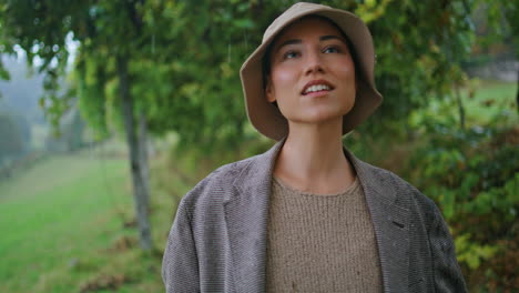 woman in a rain hat in a rainy forest