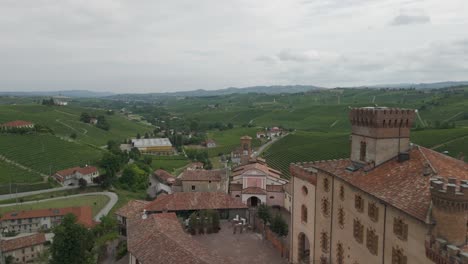 barolo castle in langhe wine region, cuneo, piedmont, italy. 4k aerial view of the village and the vineyards, flying forward, close to the castle.