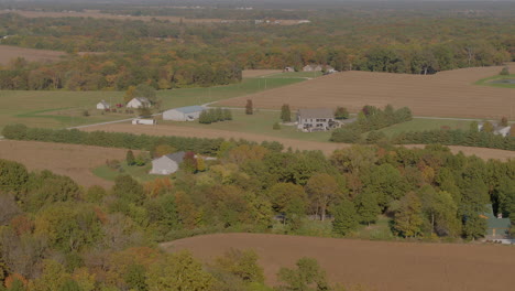 Pull-away-from-beautiful-farmland-in-the-midwest-and-over-corn-fields-at-harvest-time-in-Autumn