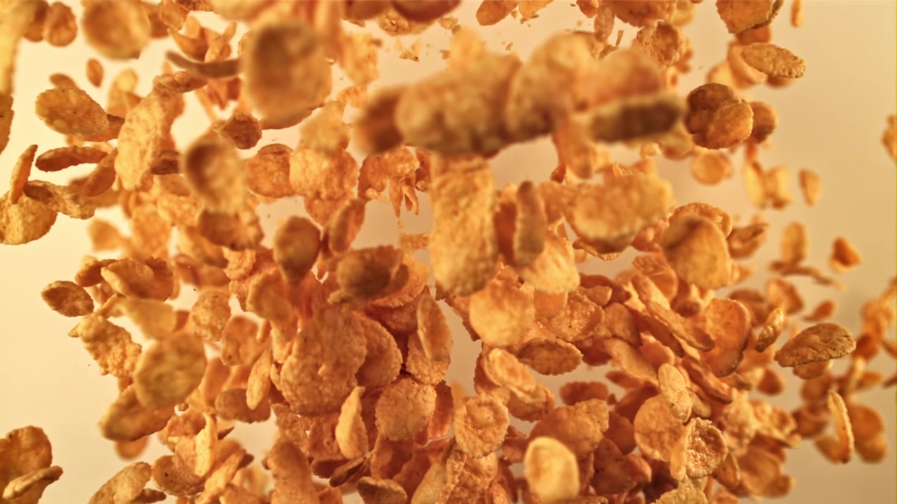 Golden Corn Flakes Cereal Falling in Slow Motion