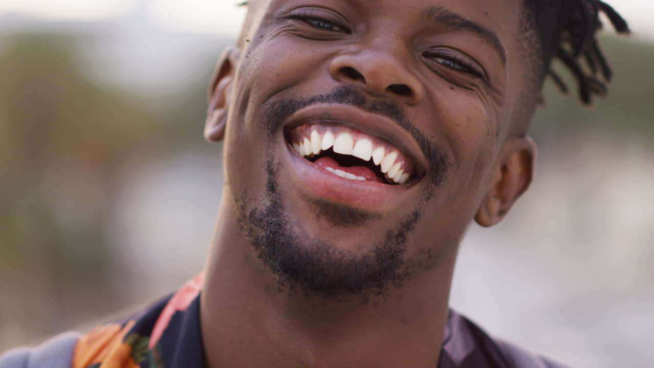Uomo afroamericano, ritratto e volto sorridente all'aperto.