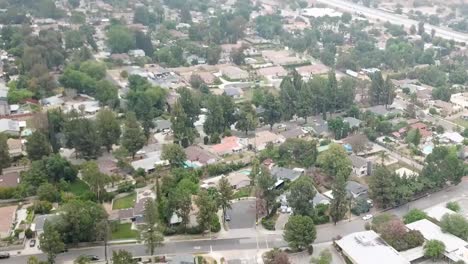 video of a drone on an overcast day surveying a neighborhood and then panning up to a view of the 210 freeway in california