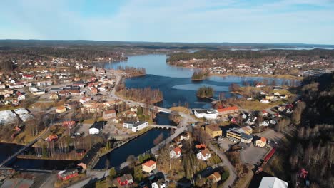 aerial view of small swedish city with natural blue lake, bridges and buildings during summer