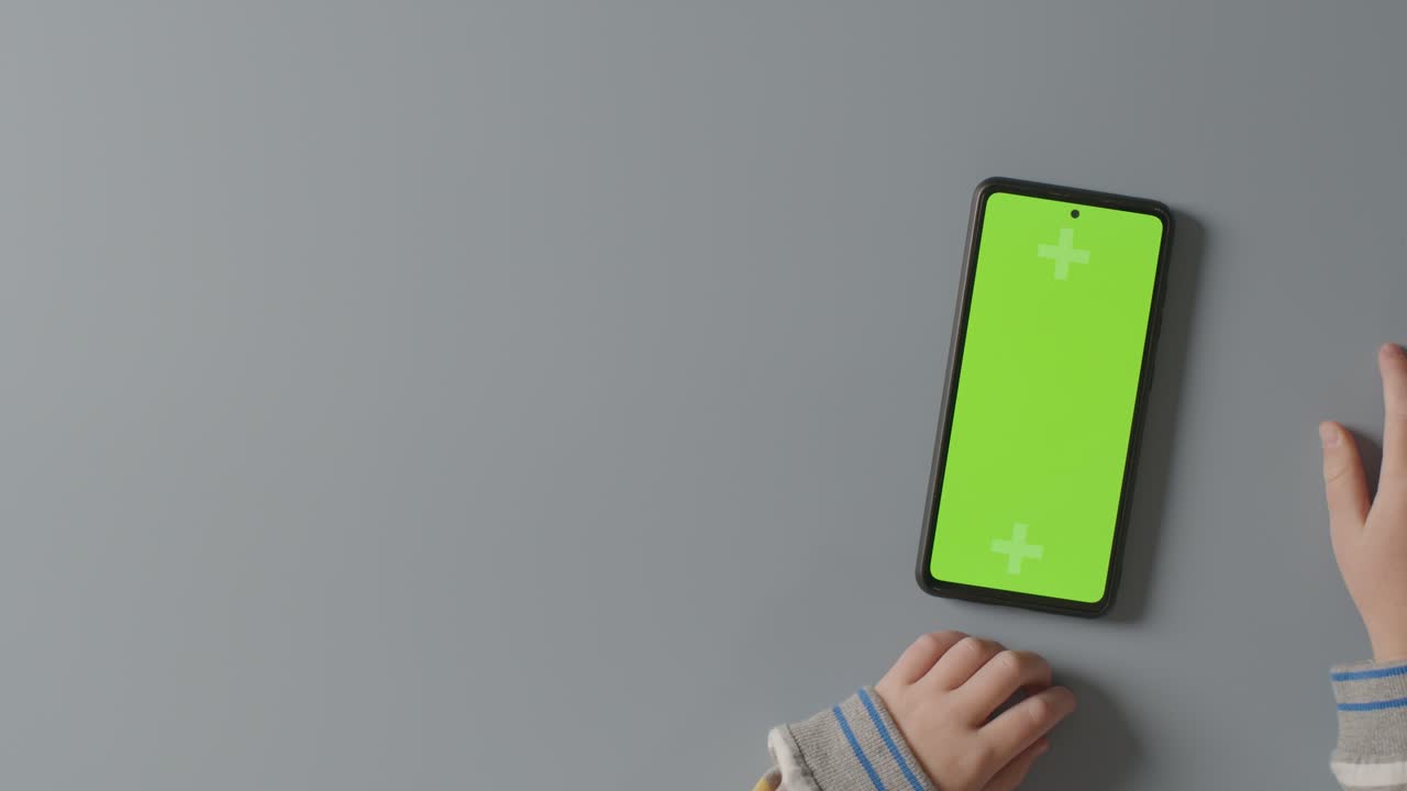 초록색 화면에 스크롤하는 아이의 오버헤드 스튜디오  ⁇  휴대 전화 1