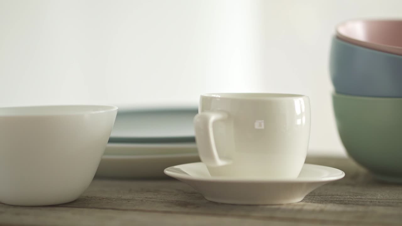 большой набор чистой посуды. стопка белых и серых тарелок и кофейной чашки и тарелки. три миски один на вершине othe