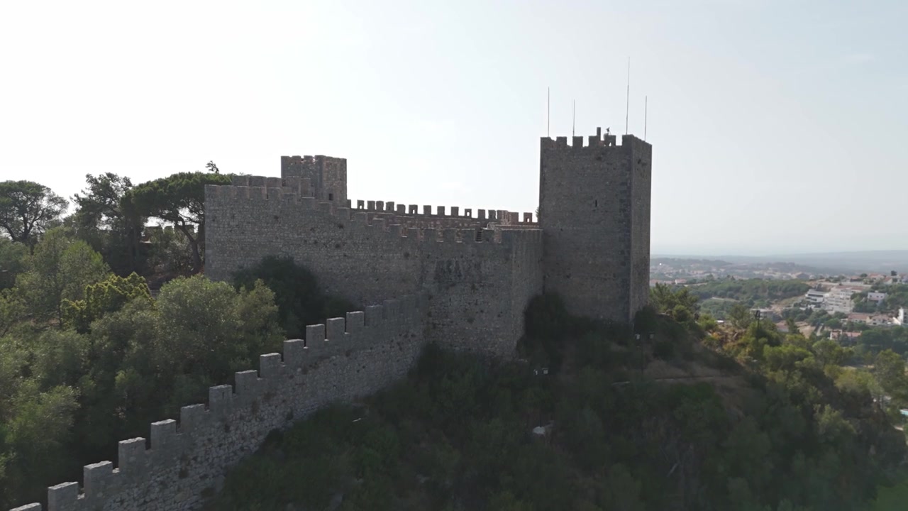 Aerea - Castello di Sesimbra in Portogallo con torri e mura merlate, pineta e città sottostante