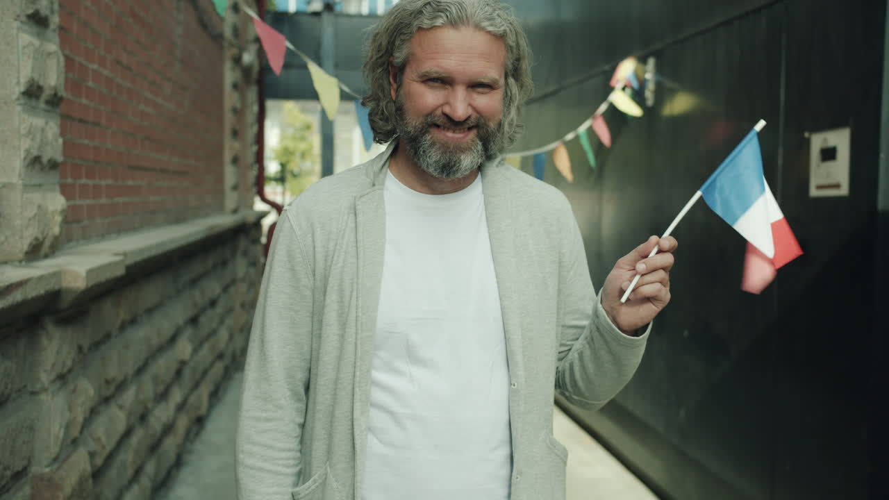 Man Holding French Flag in an Urban Alley