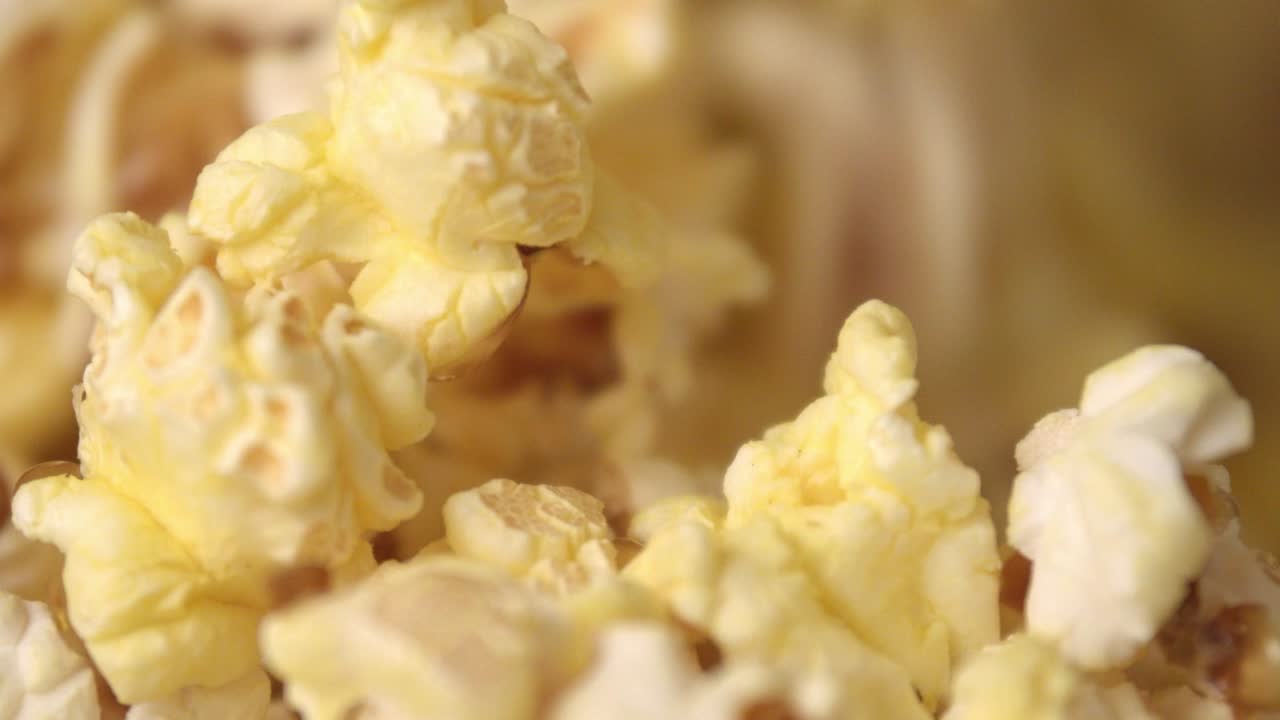 Fond de pop-corn de cinéma. Des flocons de pop-corn prêts tombent en tas au ralenti.