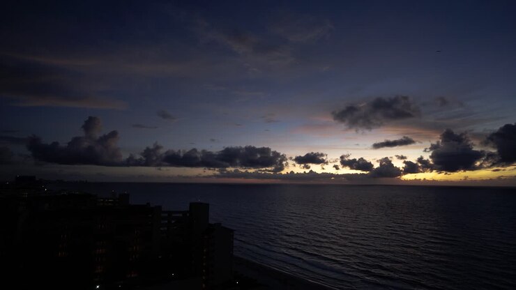 Timelapse dell'alba dietro le nuvole sull'oceano