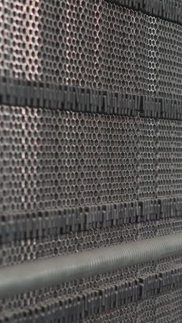 machine tool with perforated surface against pipes with thermal insulation in mechanical room closeup. heating system parts in modern boiler room