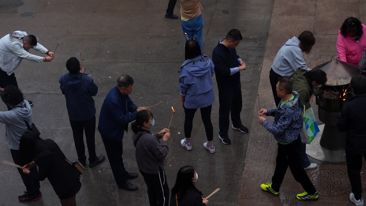 Top-down shot of people bowing and burning incense at Jingan Temple, Shanghai