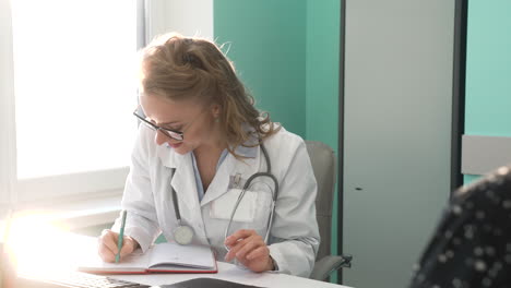 smiling female doctor attending to a patient in her consultation 2