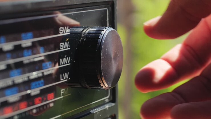 Vecchia radio AM FM retrò a valvole, mano che cambia stazione, lettore musicale vintage a valvole