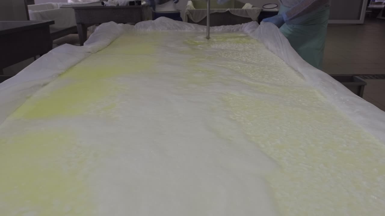 Milk pouring into the boiler at the cheese production plant