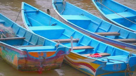 Nahaufnahme-Von-Hölzernen-Asiatischen-Ländlichen-Fischerbooten,-Die-Im-Schmutzigen-Wasser-Eines-Flusses-Schwimmen