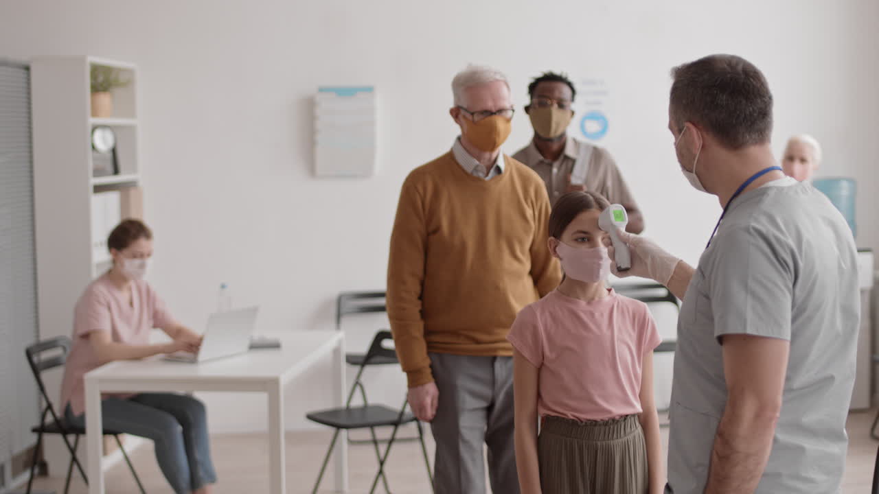 Doctor Checking Temperature of Diverse Patients
