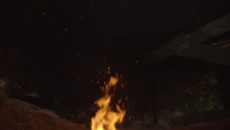 fire sparks rising from burning firewood, dark outdoor background