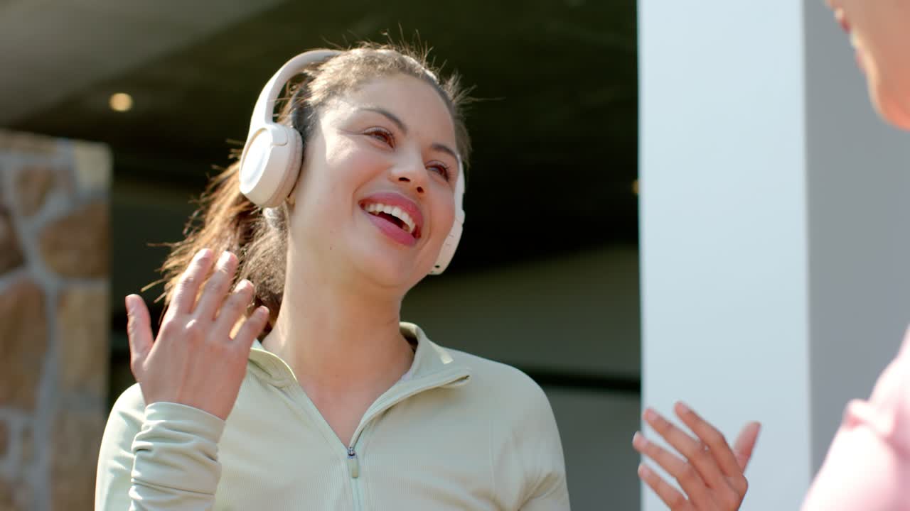 Veninder deler terrasse og lytter til musik, mens en ven tilbyder over-ear hovedtelefoner