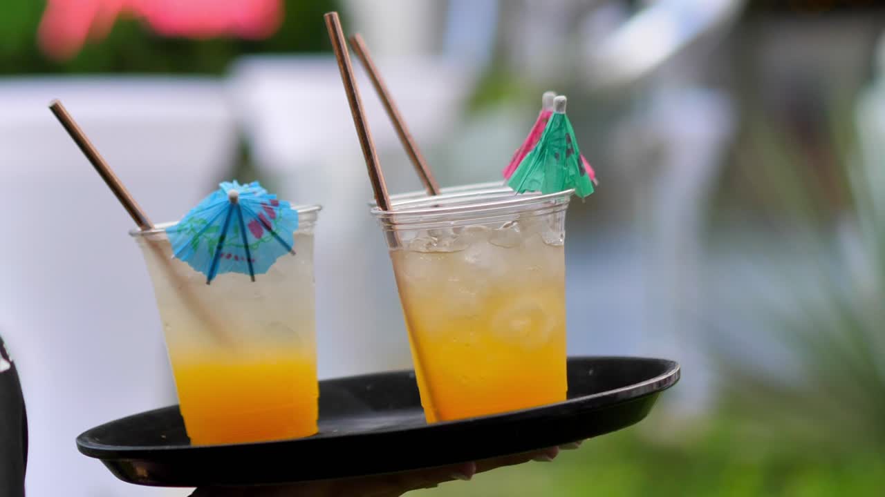 샴페인 두 잔이 담긴 쟁반을 들고 있는 웨이터가 방문자를 보여줍니다.