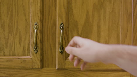 man puts plate into cupboard