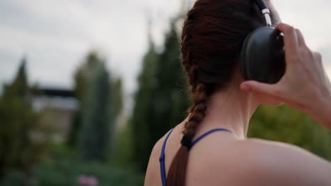 mujer caminando en un parque con auriculares