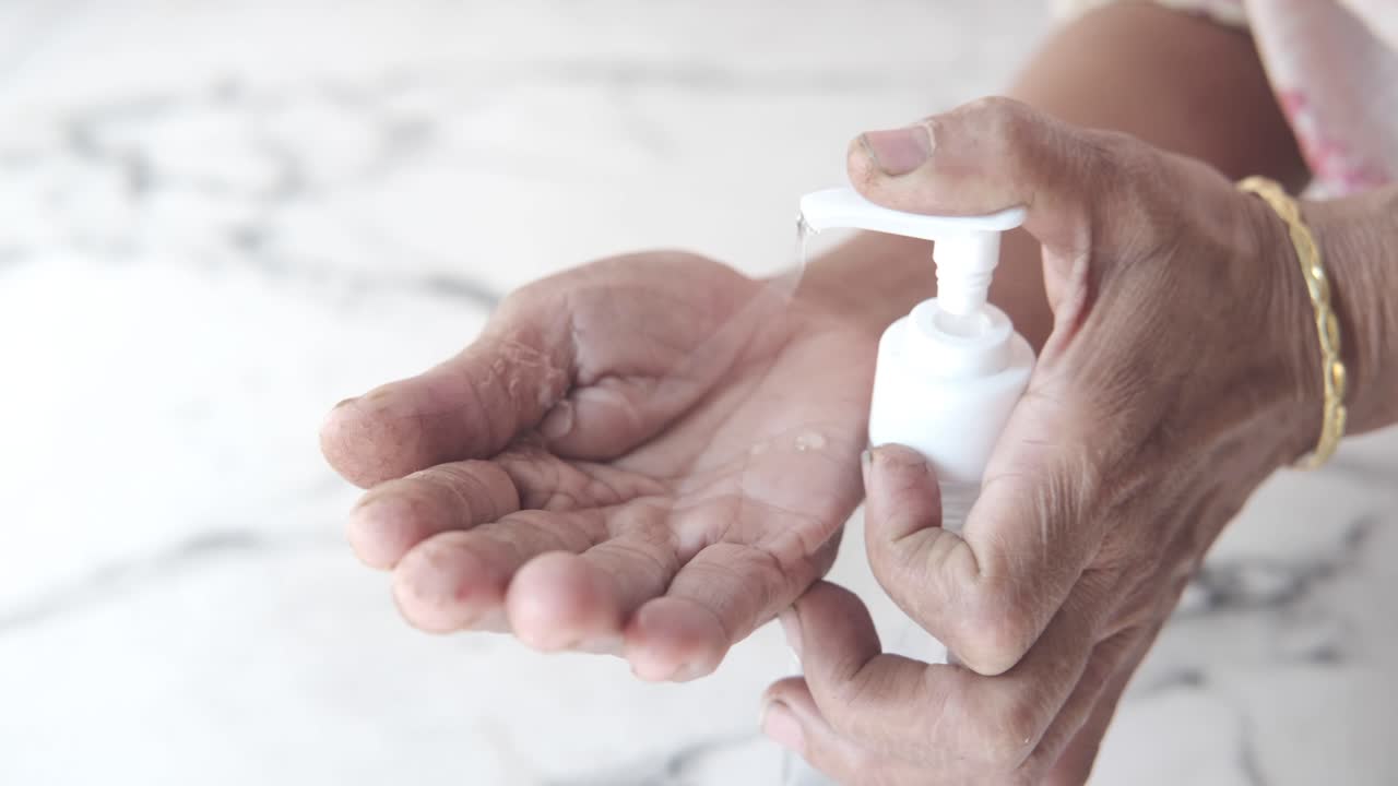 Äldre person som använder handsprit