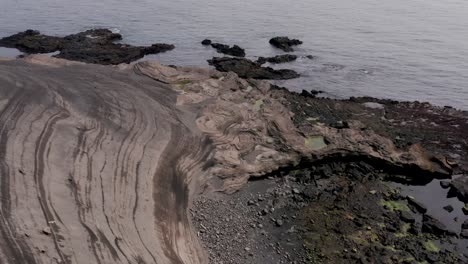 Texturas-Costeras-Grises-Formadas-Por-Años-De-Lava-Solidificada-De-Un-Volcán-Cercano