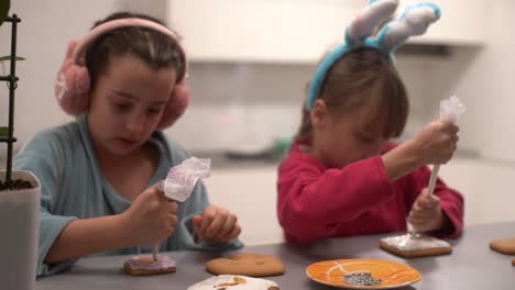 two cute sisters make and decorate cookies