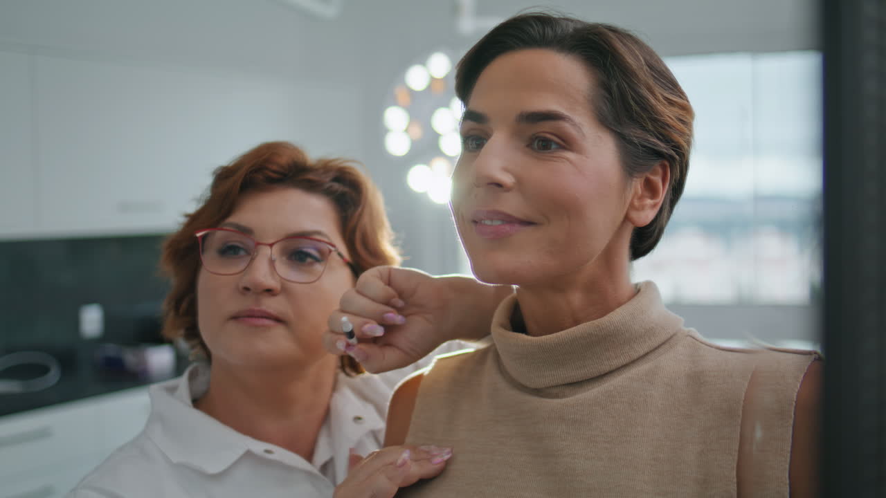 Woman looking lifting result in mirror beauty clinic closeup. Aesthetic medicine