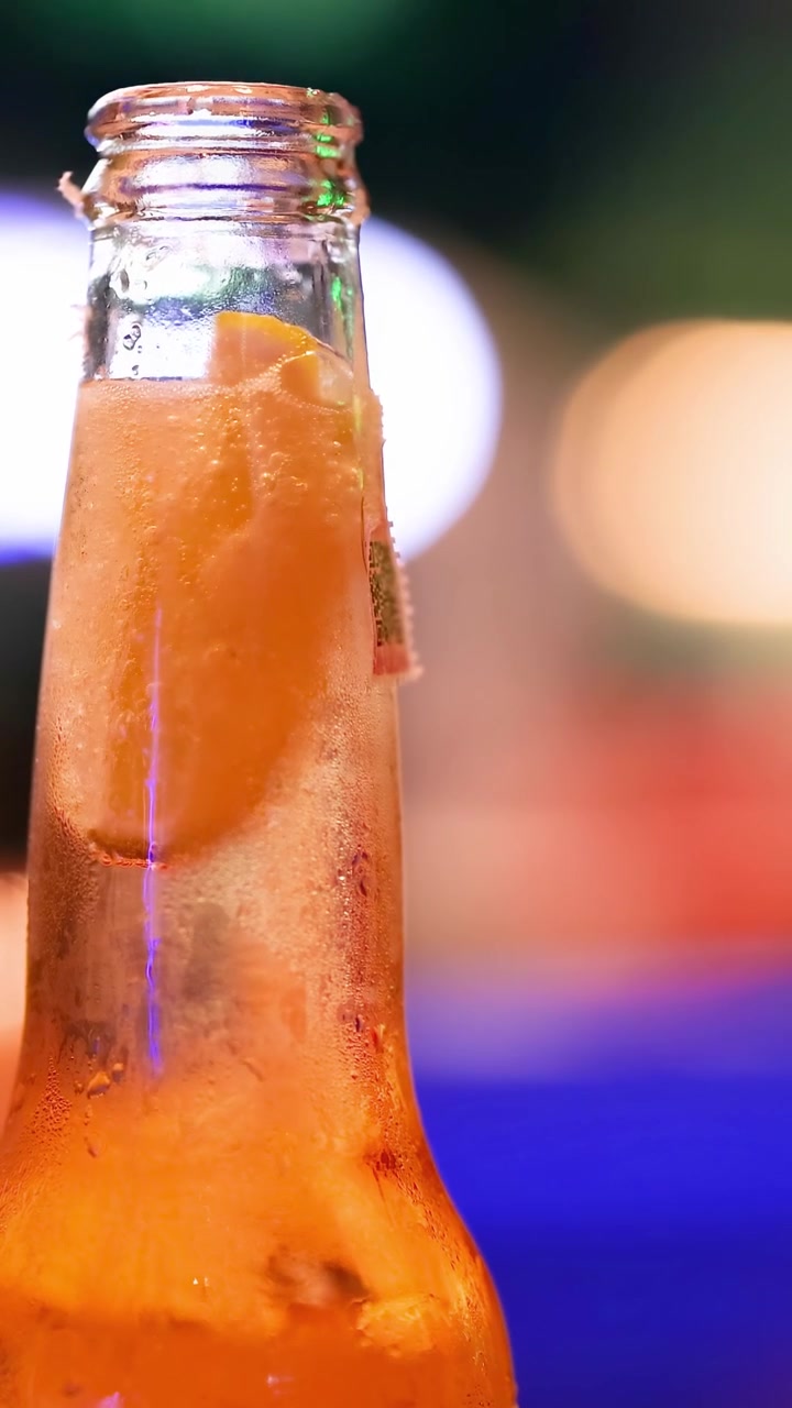 Primer plano de un refrescante cóctel de naranja en una botella de vidrio