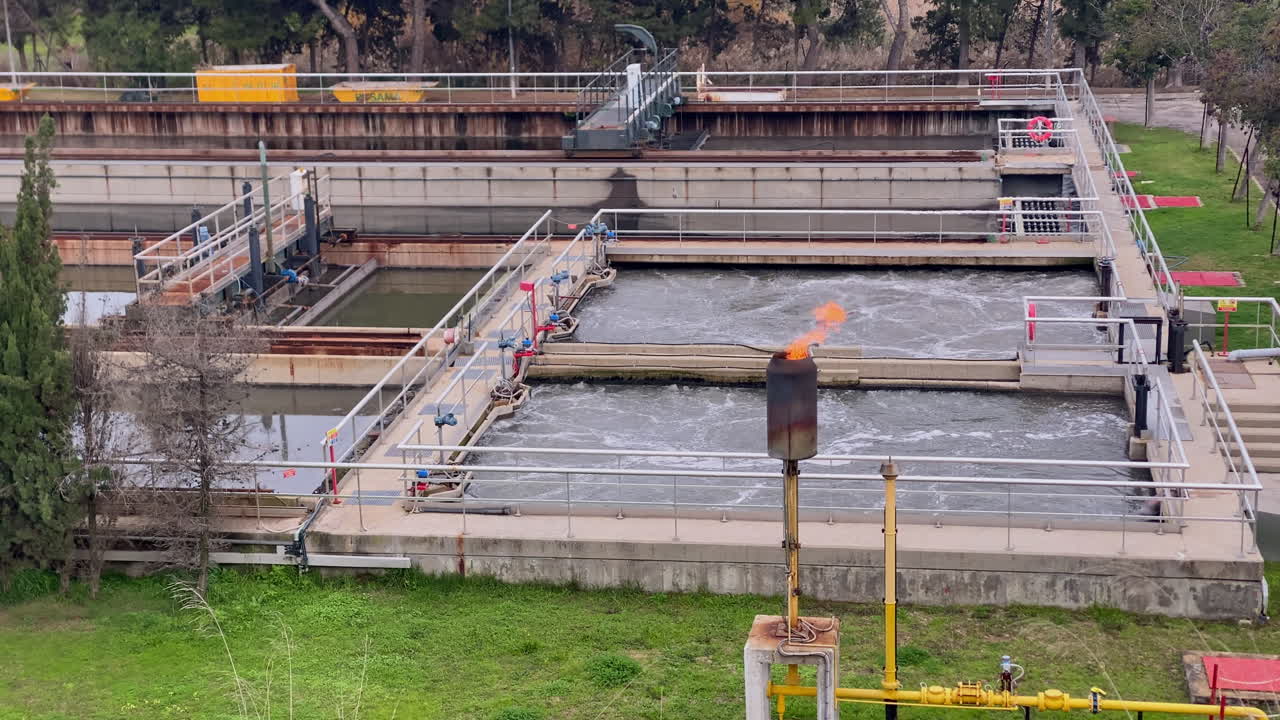 Wastewater treatment plant system with aeration tanks and a biogas flare burning excess gas, ensuring environmental managements