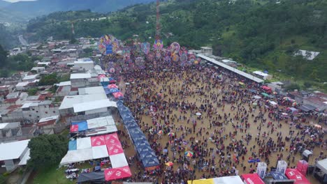 Side-panning-shot-of-big-group-people-at-Sumpango-Kite-Festival,-aerial