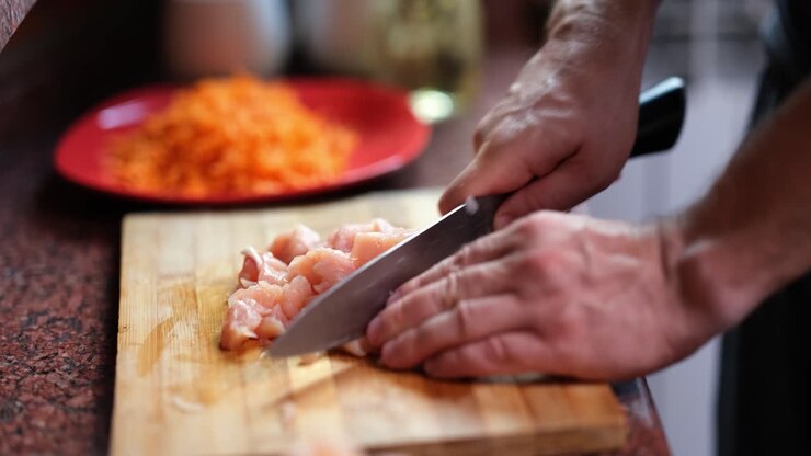 Chopping chicken on a cutting board