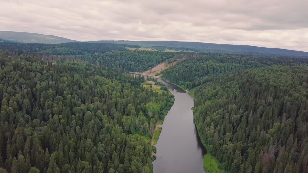 Ilmakuva joesta, joka virtaa tiheän metsän läpi