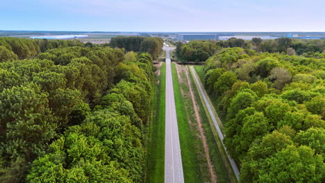 straight two-lane road away from the cities. drone footage over the highway in the countryside across the forest.