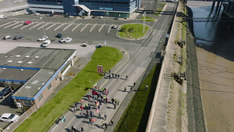 aerial view of a protest march on a road next to a river