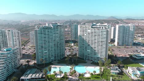 Zoom-out-aerial-view-of-exclusive-buildings-with-their-own-swimming-pool-on-the-waterfront-of-La-Serena,-northern-Chile