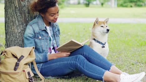 woman reading in park with dog