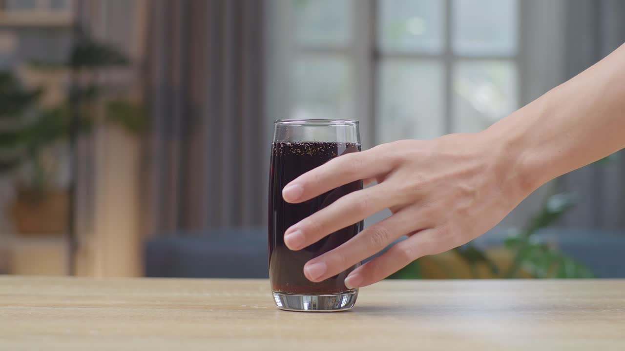 손은 테이블에 블러 컵에 신선한 콜라를 가져