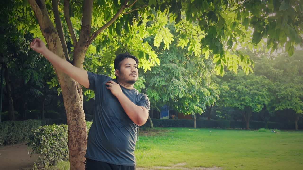 건강 한 생활 방식 을 위해 공원 에서 손 움직임 운동 을 하는 인도 의 한 젊은 남자