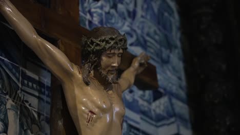 carved christ figure beneath blue portuguese tiles and sacred sorrow
