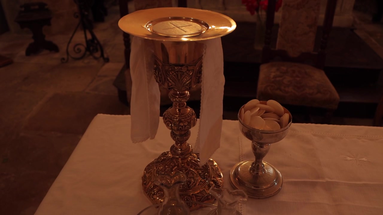 Pane e vino consacrati durante una Messa cattolica, che simboleggiano la Santa Eucaristia e la reale presenza di Cristo in una sacra celebrazione liturgica.
