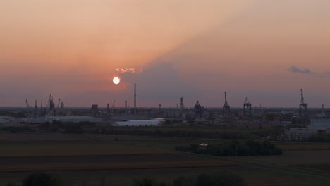 industrial and port area of ravenna ,chemical and petrochemical pole,thermoelectric,metallurgical plants and hydrocarbon refinery and liquefied natural gas tanks at sunset shot at 30 fps