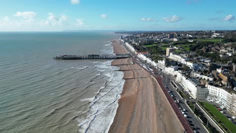 Aerial-drone-shot-of-Hastings-UK,-pull-away-shot-of-Hastings-Beach,-Hastings-Pier-and-coast-line