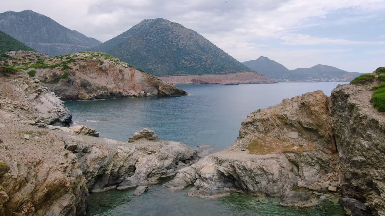 Aerial pull out over protected lagoon among rugged areas of the Greek Islands